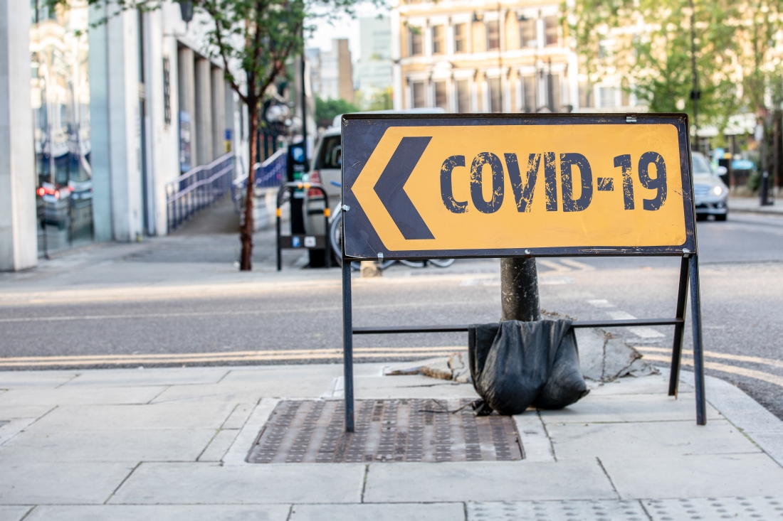 SS_COVID-19 Coronavirus - outbreak of desease that was first reported from Wuhan, China. Yellow diversion road sign in a UK city street